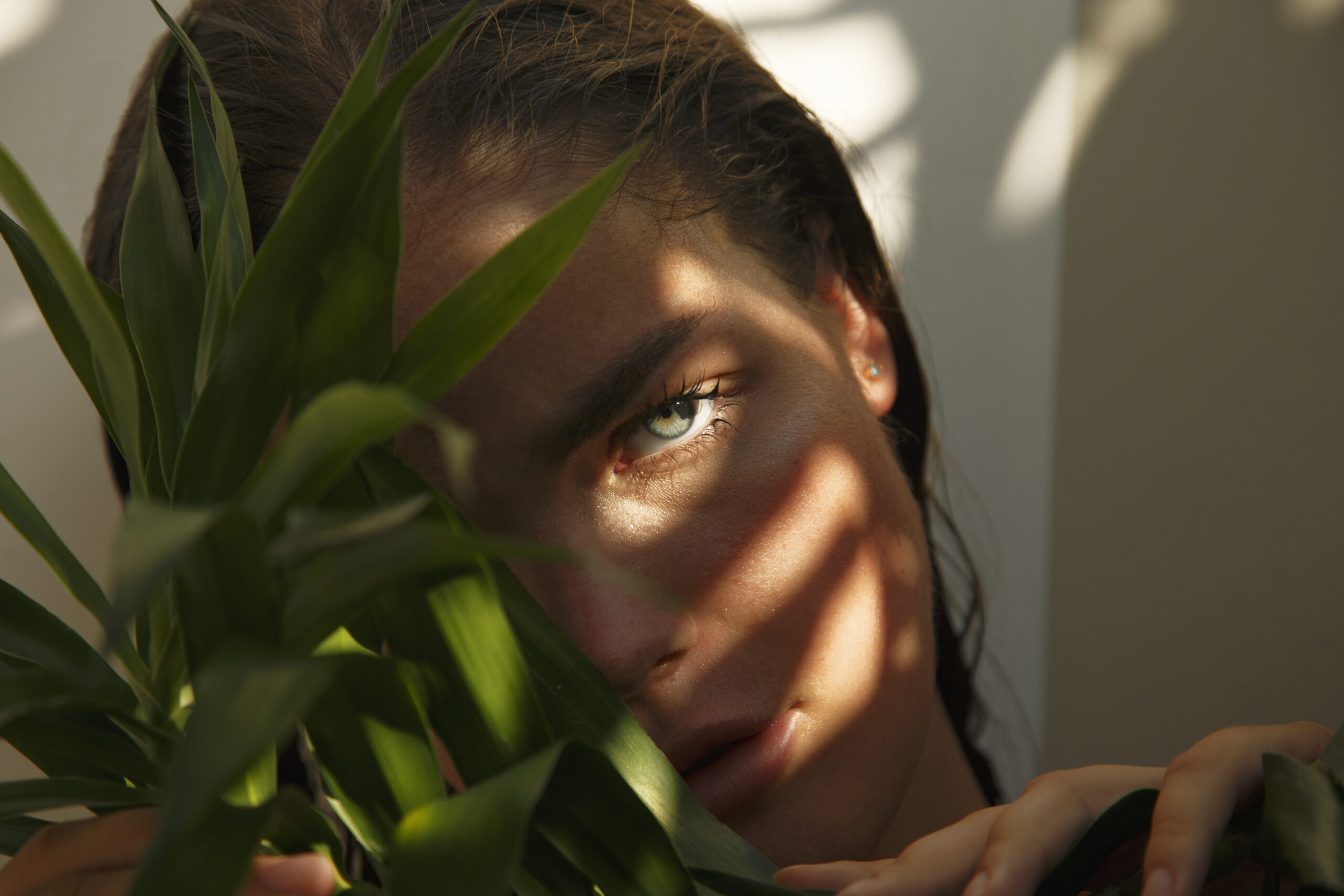 portrait-beautiful-woman-looking-out-from-palm-tree-with-shadows